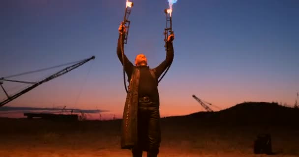 A man with a flamethrower at sunset in slow motion. Costume for zombie Apocalypse and Halloween. — Stock Video