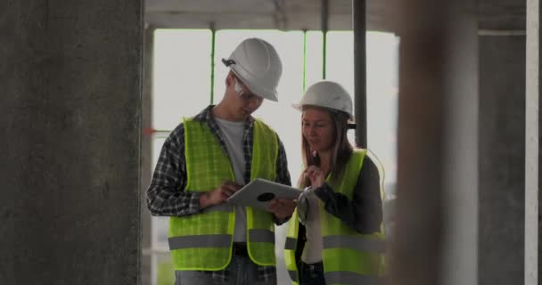 Cantiere Team o architetto e costruttore o lavoratore con caschi discutono su un piano di costruzione ponteggio o progetto o lista di controllo . — Video Stock