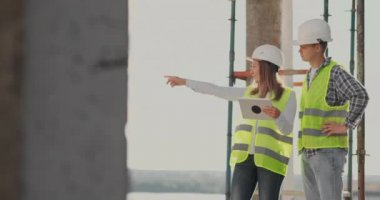 Mühendisler veya mimarlar inşaat planına bakarak şantiyede bir tartışma var. contre jour. Mühendisler veya mimarlar bir tartışma var.