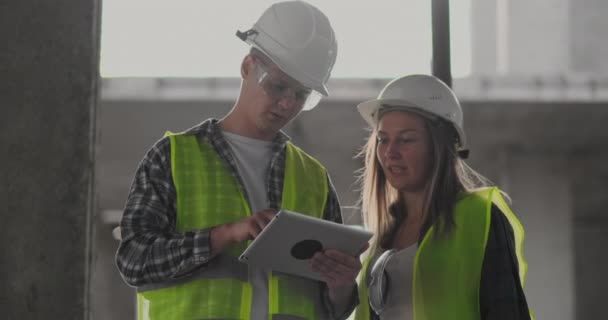 Construção Equipe ou arquiteto e construtor ou trabalhador com capacetes discutir em um plano de construção andaime ou plano ou checklist . — Vídeo de Stock
