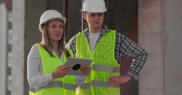 Des ingénieurs ou des architectes discutent du plan de construction sur le chantier. contre jour. Ingénieurs ou architectes ont une discussion . — Video