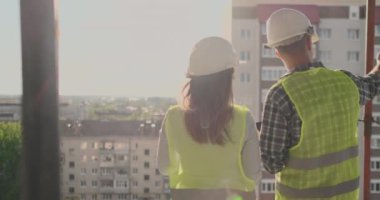 plan proje inşaat sitesi sanayi, endüstri kavramı içinde tebrik başlangıç için bina hakkında planlama mühendisi veya teknisyen erkek ve kadın tutarak mobil radyo kask ile bir kaç telefon.