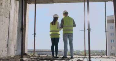 plan proje inşaat sitesi sanayi, endüstri kavramı içinde tebrik başlangıç için bina hakkında planlama mühendisi veya teknisyen erkek ve kadın tutarak mobil radyo kask ile bir kaç telefon.