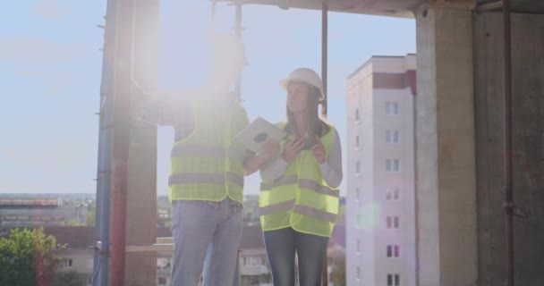 Byggteknik och människor koncept-leende byggare i hardhats med Tablet PC-dator utomhus. — Stockvideo