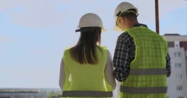 plan proje inşaat sitesi sanayi, endüstri kavramı içinde tebrik başlangıç için bina hakkında planlama mühendisi veya teknisyen erkek ve kadın tutarak mobil radyo kask ile bir kaç telefon.