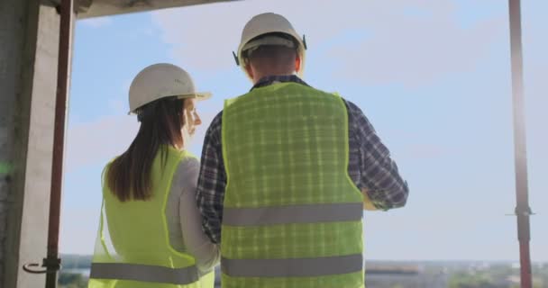 Tillbaka vände arkitekt och tekniker på byggarbetsplatsen granska Office ritningar. — Stockvideo