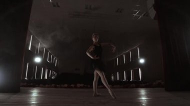 Arka planda ışık ve duman, yavaş hareket ile karanlıkta zarif bir balerin dans bale elemanları.