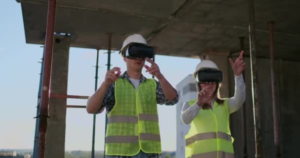 Основні інженери заводу, що несуть VR гарнітура, проектує будівлю, що знаходиться на місці будівництва. Віртуальні програми гібридної реальності. — стокове відео