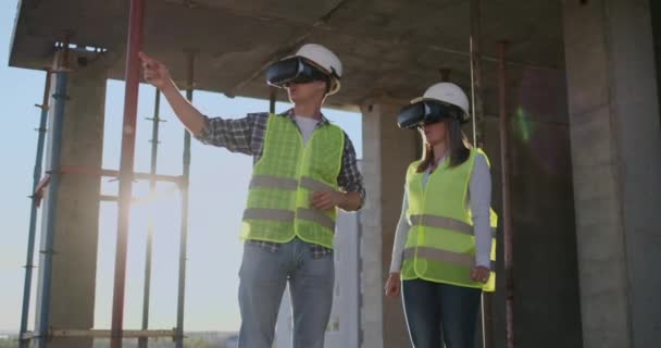 Портрет двох сучасних будівельників, що використовують VR-обладнання для візуалізації проектів на місці, копіювання простору . — стокове відео