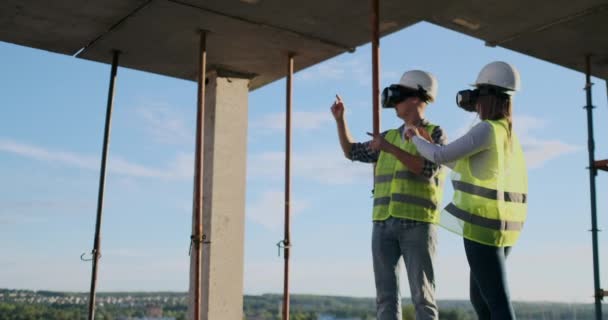 Midja upp porträtt av två moderna byggnadsarbetare använder VR redskap för att visualisera projekt på plats, kopiera utrymme. — Stockvideo