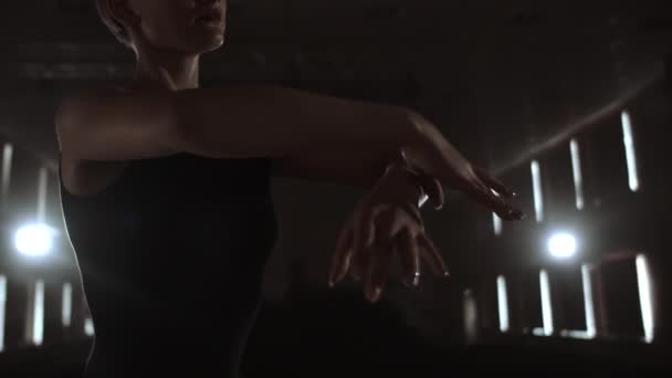 Femme gracieuse ballerine dans une robe sombre sur une scène sombre du théâtre dans la fumée effectue des mouvements de danse au ralenti — Video