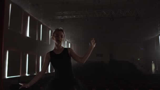 Prima balett cég egy sötét ruhában egy sötét színházi színpadon próbálni a füst végez táncmozgások lassítva — Stock videók