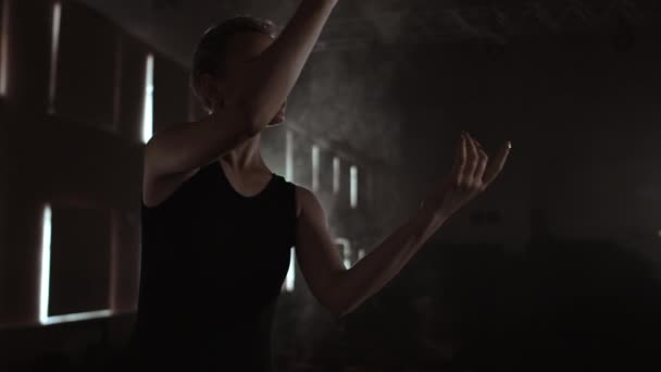 Primaballett in dunklem Kleid auf dunkler Theaterbühne probt im Rauch Tanzbewegungen in Zeitlupe — Stockvideo