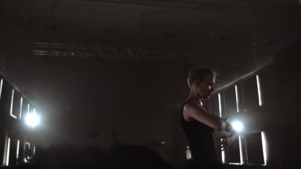 Close-up van ballet danseres terwijl ze oefeningen op Dark stage of Studio beoefent. Ballerina toont klassieke ballet pas. Slow Motion. Flare, Gimbal schot — Stockvideo