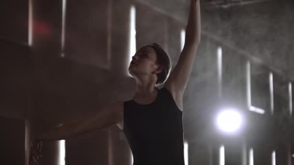 Nahaufnahme einer Balletttänzerin beim Üben auf dunkler Bühne oder im Studio. Ballerina zeigt klassischen Ballett-Pas. Zeitlupe. Fackel, Gimbellauf — Stockvideo