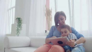 Anne ve oğul evde dijital tablet ile oynuyor. Genç Anne ile onu 5 yıl eski Smiling ile Digital Tablet içinde ev.