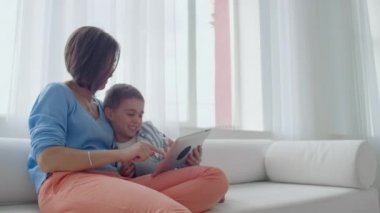 Anne ve oğul evde dijital tablet ile oynuyor. Genç Anne ile onu 5 yıl eski Smiling ile Digital Tablet içinde ev.