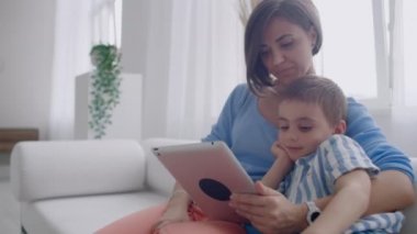 Anne ve oğul evde dijital tablet ile oynuyor. Genç Anne ile onu 5 yıl eski Smiling ile Digital Tablet içinde ev.