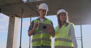 Mühendis tasarımcı kadın İnşaat ilerleme ile tartışmak inşaat adam altında bir binanın danışmanı ve bir bina planı inceliyor