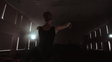 Bir balerin boş koltuklu bir salonda dans ediyor. Bir kadın dansçı boş bir sahnenin sessiz ve hiçbir izleyici sahiptir.
