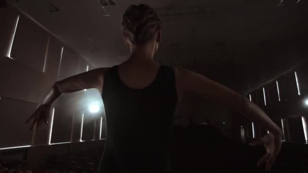 Pomalý pohyb: Prima balet na jevišti, který zkouší představení v tmavém světle Contra. Světla z haly. — Stock video