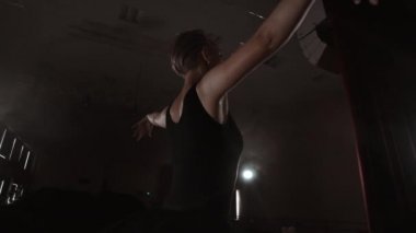 Bir balerin boş koltuklu bir salonda dans ediyor. Bir kadın dansçı boş bir sahnenin sessiz ve hiçbir izleyici sahiptir.