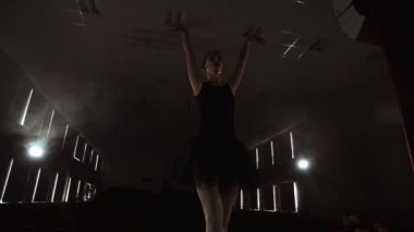 Yavaş hareket: bir siyah elbise Prima bale rotasyonlar gerçekleştirir ve solo program prova dans zarif hareketler. Kamera gimbal üzerinde hareket eder