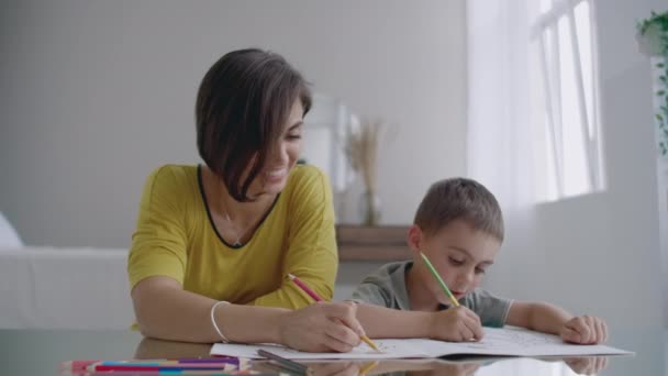 Mujer joven y niño dibujando juntos haciendo fotos con lápices en plano . — Vídeo de stock