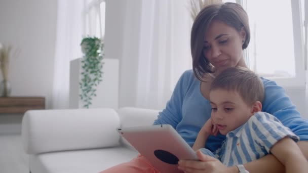 Madre e hijo jugando con la tableta digital en casa. Joven madre con sus 5 años sonriendo con la tableta digital en casa . — Vídeo de stock