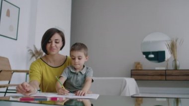 Genç kadın ve çocuk yapım resmi dairede kalemler ile çizim birlikte.