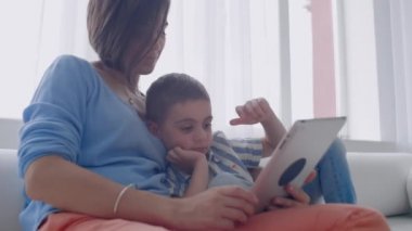 Anne ve oğul evde dijital tablet ile oynuyor. Genç Anne ile onu 5 yıl eski Smiling ile Digital Tablet içinde ev.