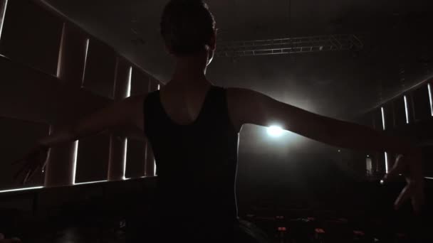 SLOW MOTION : prima ballet répète une performance solo debout sur la scène du théâtre en fumée dans une robe noire à la lumière — Video