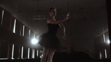 Sigara ile stüdyoda siyah tutu zarif Bale dansçısı. Ve arkadan aydınlatmalı.