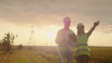 Yüksek gerilim kulesi üzerinde çalışan mühendislik, tablet bilgisayar iki çalışanı erkek ve kadın bilgi kontrol edin.