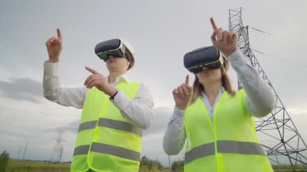 Twee ingenieurs van Power Engineers in vr-brillen bewegen hun handen om de werking van de interface van het besturingssysteem te simuleren — Stockvideo