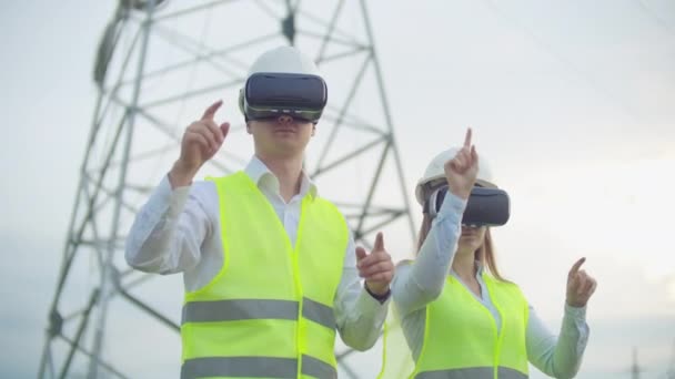 Los ingenieros trabajan con realidad aumentada utilizando gafas de realidad virtual 3D. Ingeniero femenino y masculino trabaja con gafas VR mientras un hombre sostiene — Vídeo de stock