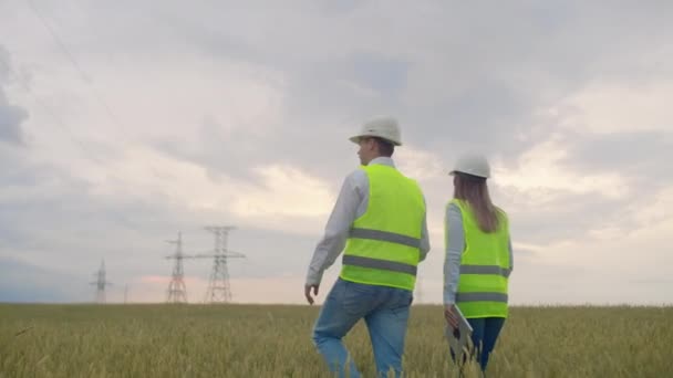 Hinten zwei der Ingenieur und der Controller mit Tablet-PC und die Zeichnungen beschäftigen sich mit Linien und Sendemasten und diskutieren den Ausbauplan und die Transportenergie für Städte — Stockvideo