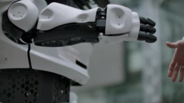 İnsan ve yapay zeka modern teknolojilerin etkileşimi. Erkek el bilim adamı yakın yukarı robotik kol sallar. Robotik ve insan elleri el sıkışmasına katılır. Toplantı ve arkadaşlar tebrik