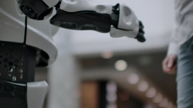 Android bir robotla el sıkışan bir iş adamının eli. Yapay zekayla insan etkileşimi kavramı