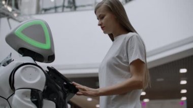 Robot kıza bakıyor. Yapay zeka. Modern robot teknolojileri. Robot aşık gözlerle kıza bakıyor. Modern robotik teknolojiler.