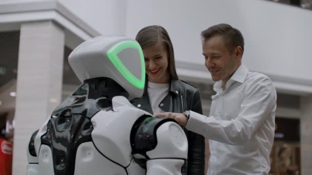 Nowoczesne technologie robotyczne interakcji z ludźmi. Przyjaźń i komunikacja pary z robotem. Asystent przyszłości. Robot patrzy na kamerę na osobę. — Wideo stockowe