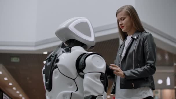 Femme heureuse en contact avec le robot cyborg. Cliquez sur l'écran du robot. Un droïde interagit avec une femme . — Video