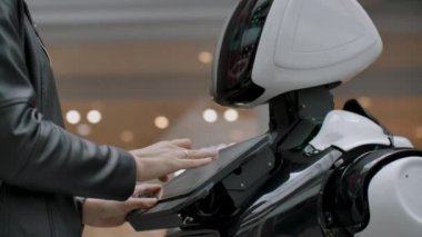 Cyborg robotuyla temas halinde olan mutlu kadın. Robot ekranına tıklayın. Bir droid bir kadınla etkileşime girer..