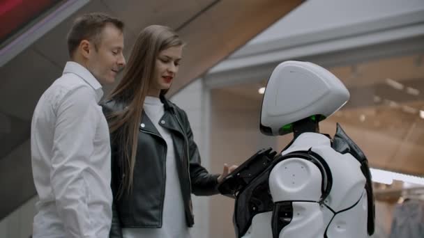 Nowoczesne technologie robotyczne interakcji z ludźmi. Przyjaźń i komunikacja pary z robotem. Asystent przyszłości. Robot patrzy na kamerę na osobę. — Wideo stockowe