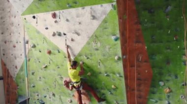 Dağcı sigorta üzerinde bir ip ve yükseklik üstesinden tebeşir için bir çanta ile bir odada dağda hareket yavaş hareket üst yükselir.