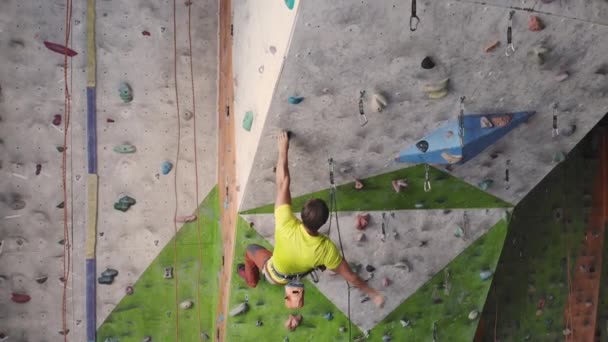 Young Woman Rock climber is Climbing At Inside climbing Gym. slim pretty Woman Exercising At Indoor Climbing Gym Wall. — Stock Video