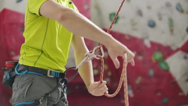 Man belaying another climber with rope. Top view of young athletic man belaying and watching another climber with rope. Summer time. Climbing equipment — Stock Video