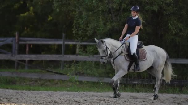 Pomalý pohyb zblízka. Ženská žokej jede na koni. Ženský žokej jede na koni v ohradě. — Stock video