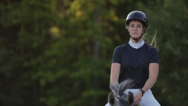Pomalý pohyb zblízka. Ženská žokej jede na koni. Ženský žokej jede na koni v ohradě. — Stock video