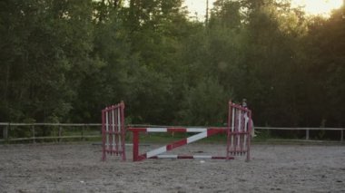 Genç kadın bir arenada onu eğitim sırasında bir engel üzerinden at atlar. Genç kadın bir arenada bir olay sırasında bir engel üzerinden at atlar. Spor. Amaçları.
